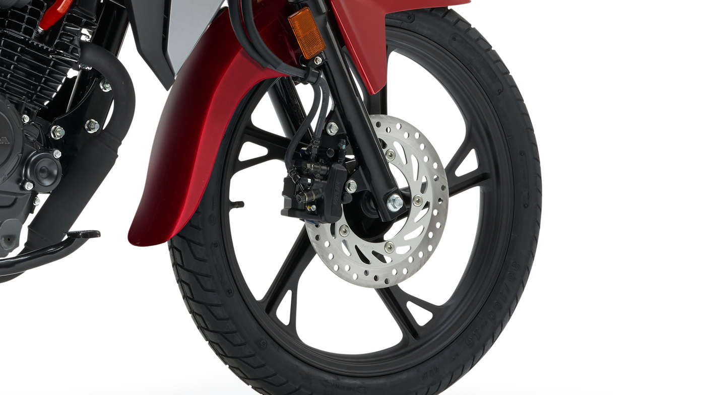 Fotografia de estúdio da Honda CB125F vermelha, destaque para a roda dianteira e o travão