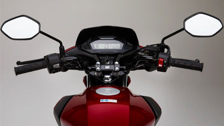 Fotografia de estúdio da Honda CB125F vermelha, destaque para o ecrã LCD