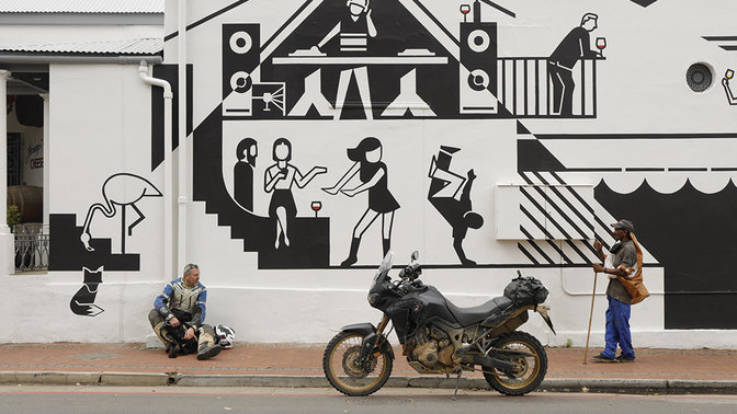 Piloto sentado junto a uma parede com grafitti.