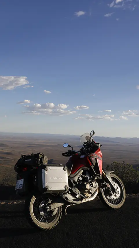 Honda CRF1000L Africa Twin estacionada ao lado da estrada com vista para o deserto do Karoo.
