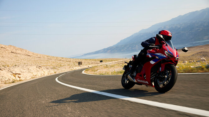 Vista dianteira dinâmica a três quartos da CBR650R com condutor