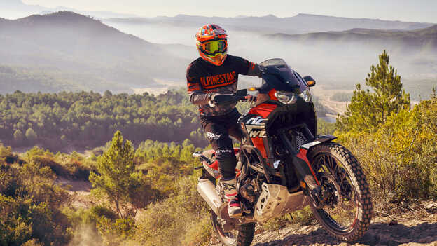 Vista dianteira a três quartos da Honda Africa twin conduzida em terreno acidentado