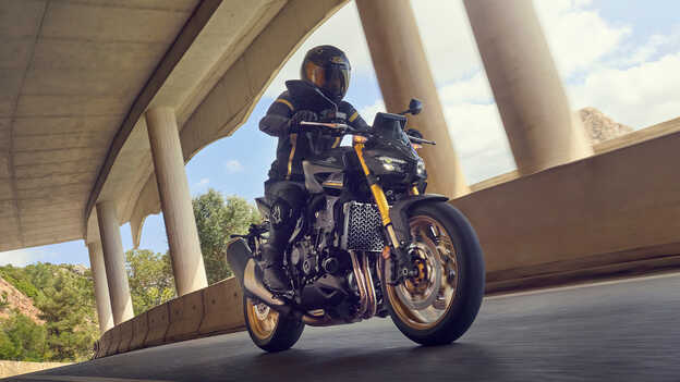 Imagem traseira estática a três quartos da Dax 125 à beira-mar.