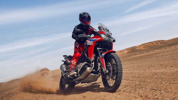 Modelo da moto CRF1100L Africa Twin num cenário de deserto.