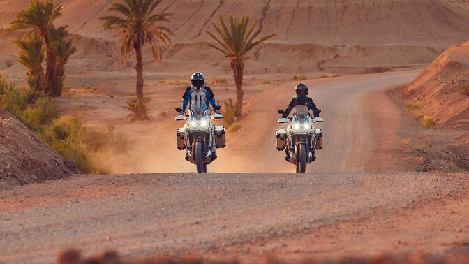 Duas motos CRF1100 Africa Twin Adventure Sports em estrada de terra