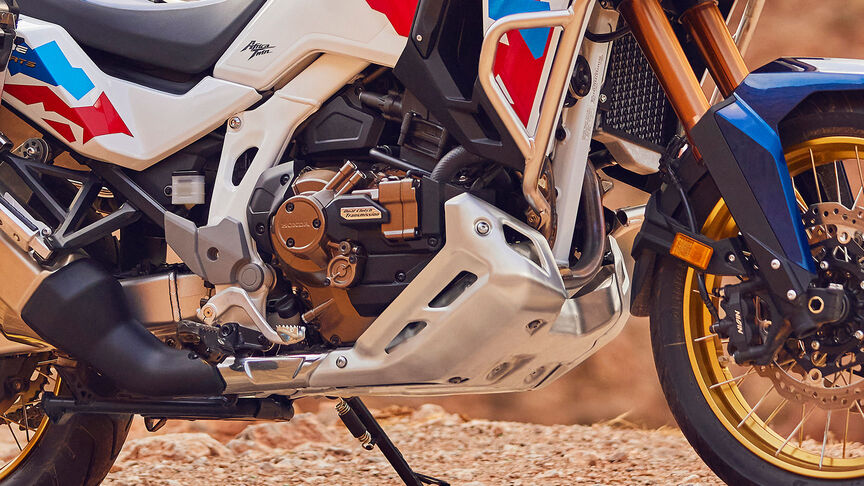 Vista frontal da Honda CRF1100 Africa Twin Adventure Sports a 3/4 num cenário montanhoso.