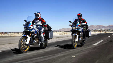 Dois condutores circulam pela estrada em motos Honda Africa Twin Adventure Sports.