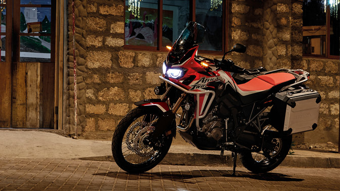 Honda Africa Twin estacionada à porta de um restaurante.