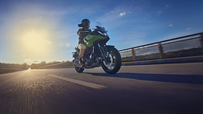 Modelo a conduzir a moto NC750X numa estrada.