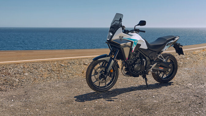 Fotografia lateral da Honda NX500 fora de estrada junto à costa