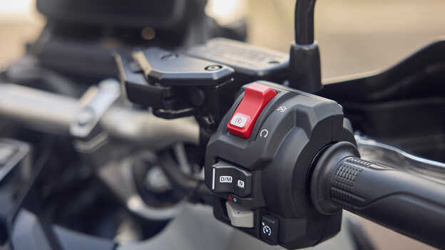 Grande plano do controlo da velocidade de cruzeiro no guiador da X-ADV