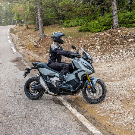 Honda X-ADV, lado direito, com condutor, moto cinzenta, pista florestal