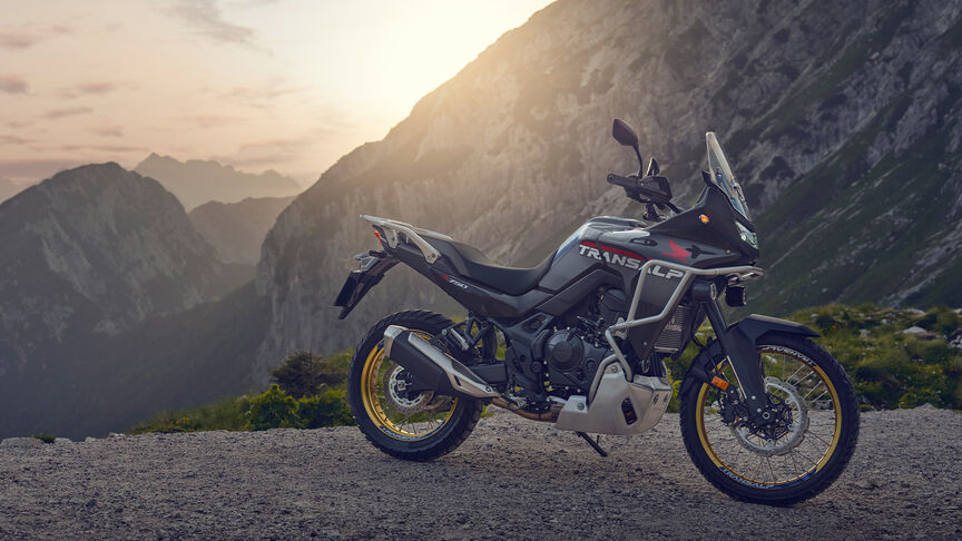 Modelo a conduzir uma moto XL750 Transalp num cenário florestal.