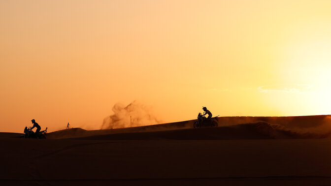 Participantes da Honda Adventure Roads no deserto ao pôr do sol.