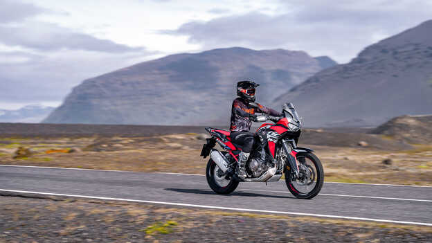 Vista dianteira a três quartos Africa Twin com condutor na estrada