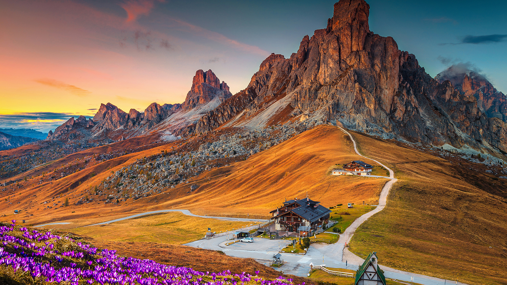 Maravilhosa paisagem alpina com flores de açafrão da primavera na colina e espetaculares montanhas ao pôr-do-sol, passo de Giau, Dolomitas, Itália, Europa