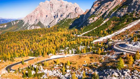 Passo Valparola, Itália. Vista da estrada em forma de serpentina no Tirol, Alpes Dolomitas. Vista da montanha Cima Cunturines (3064 m) a partir do Passo di Valparola no outono, perto de Cortina d'Ampezzo, Belluno, em Itália