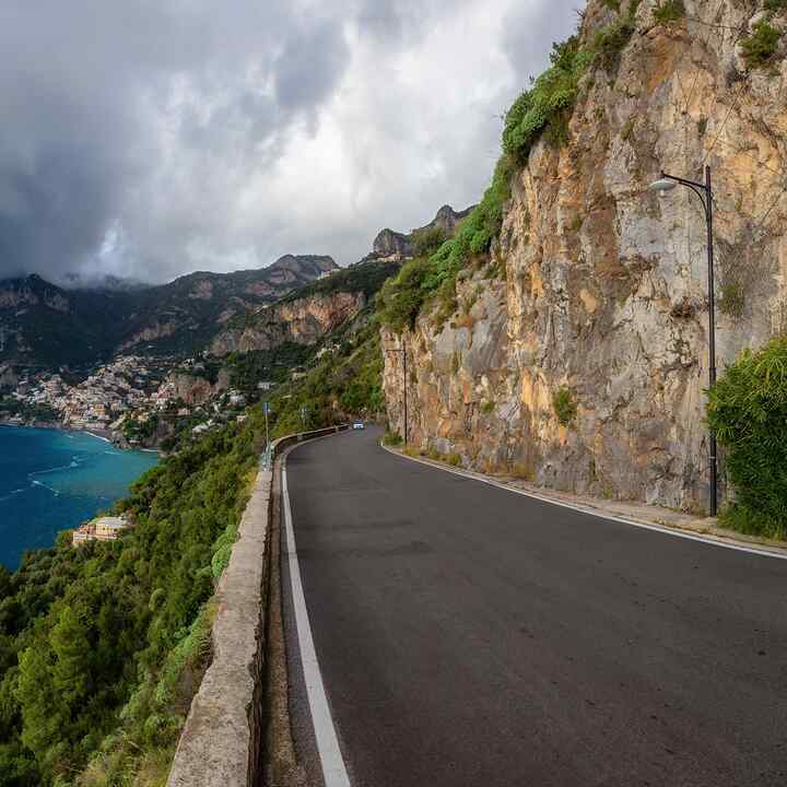 Estrada panorâmica sobre falésias rochosas e cenário de montanha junto ao mar Tirreno. Costa Amalfitana, Positano, Itália. Viagens de aventura. Vista panorâmica