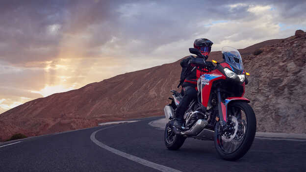 Vista dianteira a três quartos Africa Twin com condutor na estrada