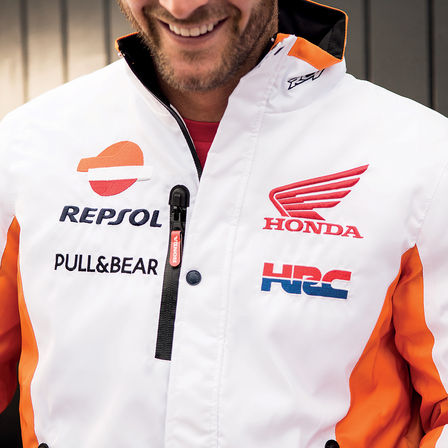 Homem a sorrir com uma camisola de competição Honda.