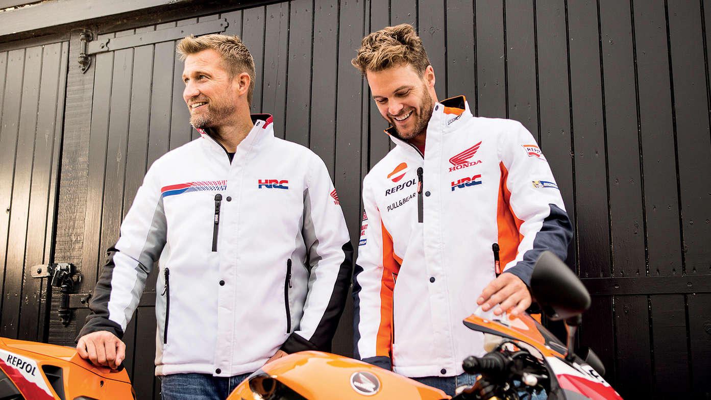 Dois homens a sorrir com casacos brancos de competição Honda