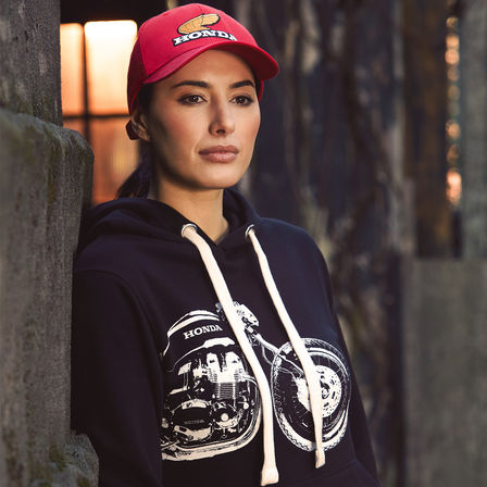 Mulher com casaco com capuz e gorro Honda vintage. 