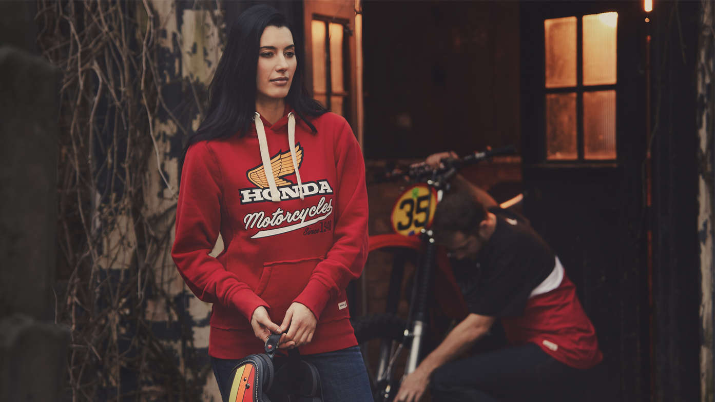 Homem e mulher vestidos com casaco com capuz vermelho Honda vintage. 