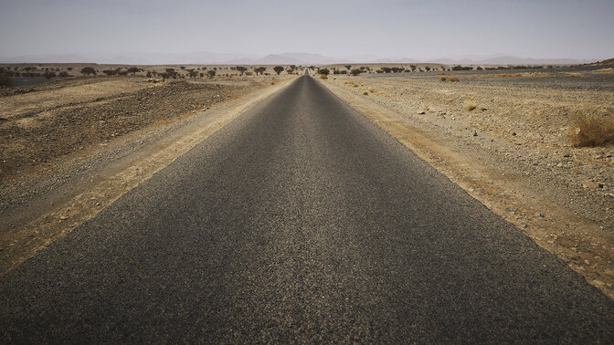 Longa autoestrada marroquina rodeada de deserto. 