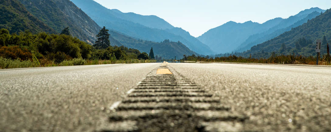 Estrada de asfalto aberta em direção às montanhas