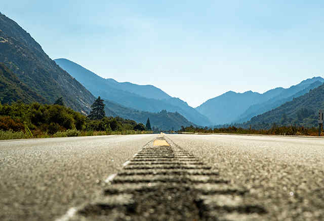 Estrada de asfalto aberta em direção às montanhas