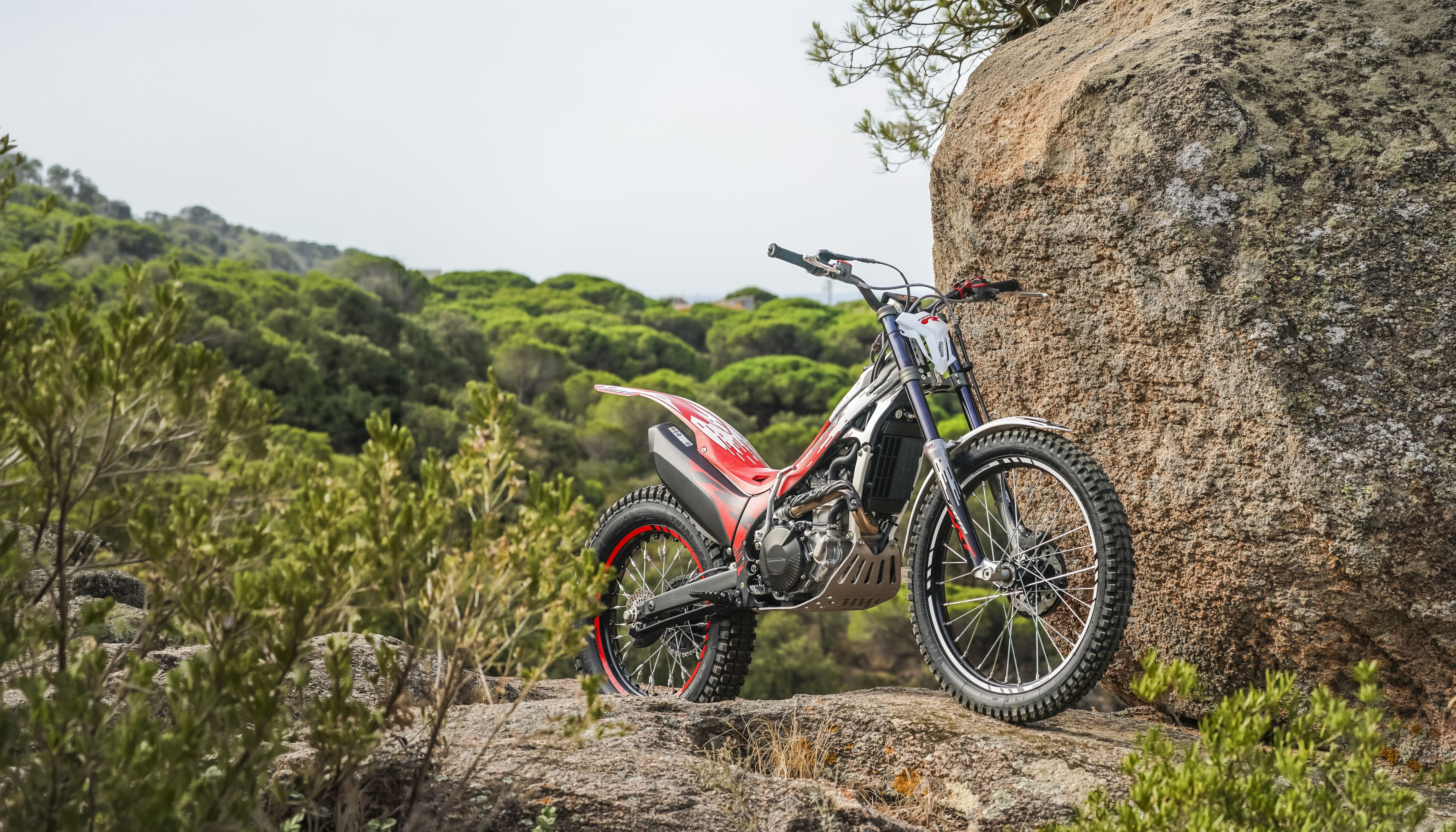 Moto de trial Montesa Cota 301RR em terreno rochoso ao ar livre.