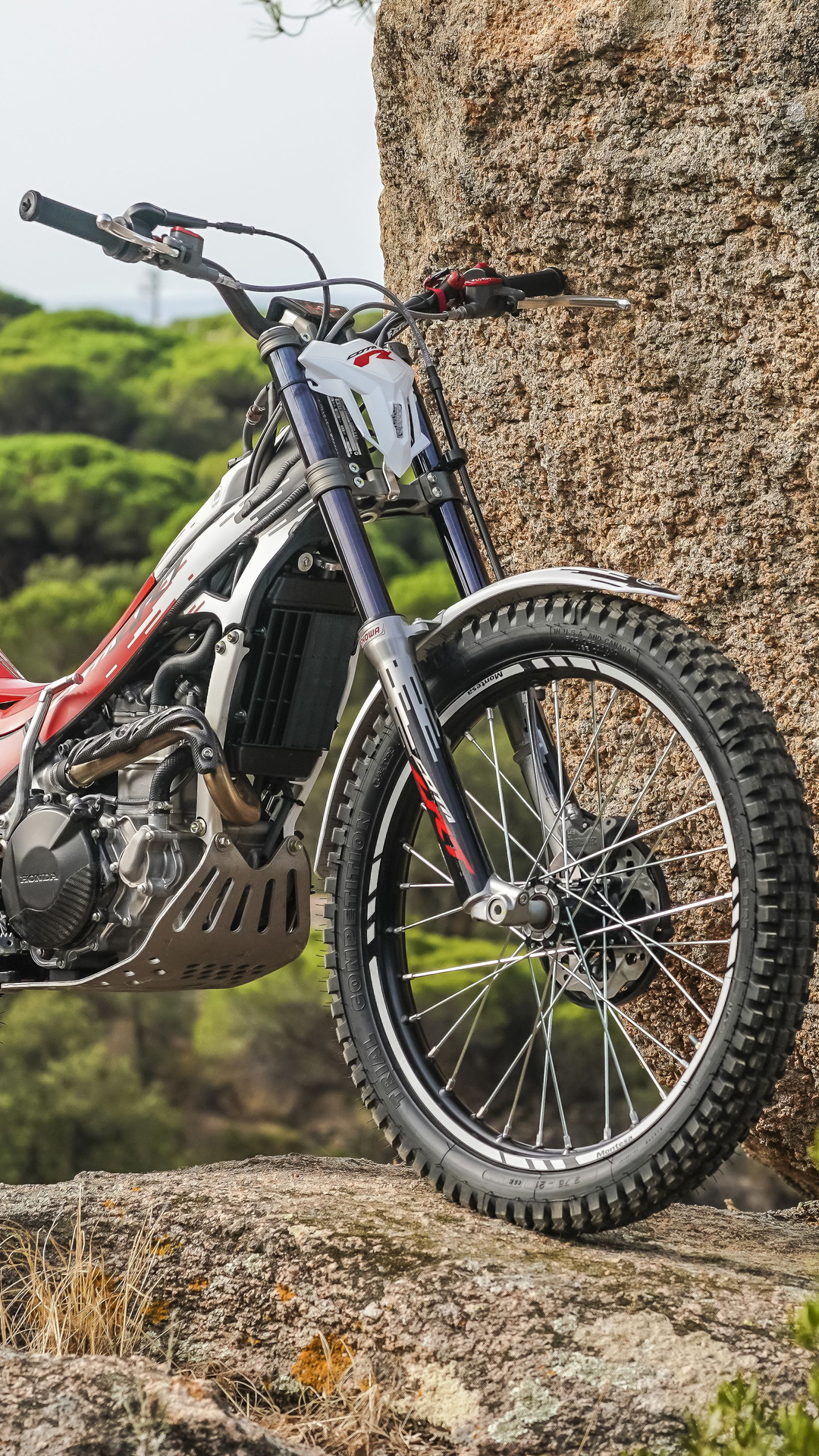 Moto de trial Montesa Cota 301RR em terreno rochoso ao ar livre.
