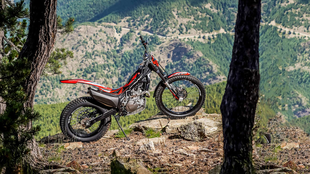 Vista lateral da Honda Montesa Cota 4RT 260R numa floresta.