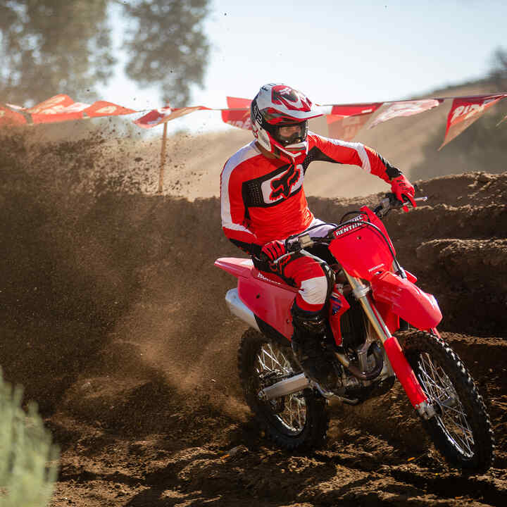 Honda CRF450R conduzida fora da estrada com montanhas ao fundo.