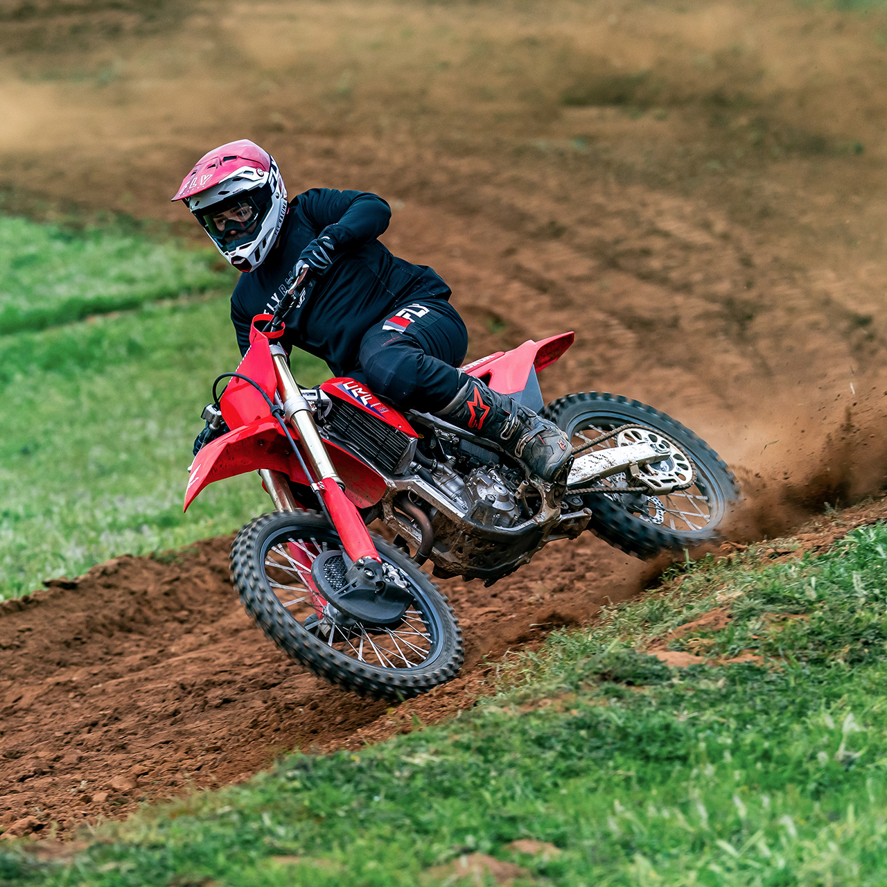 Imagem dinâmica da Honda CRF250R em pista com um piloto de motocross