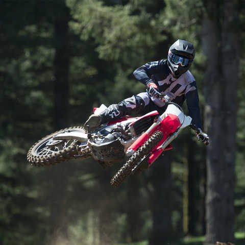 Vista dianteira da moto CRF450R a saltar, com condutor.