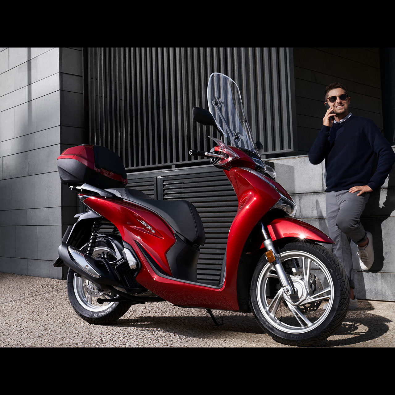 O meu telemóvel junto à scooter Honda.