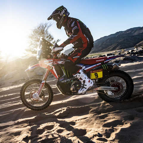 Lado esquerdo da Honda CRF450 a atravessar dunas de areia.