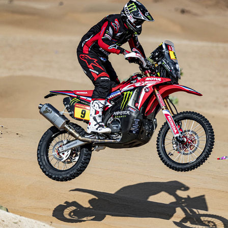 Piloto Honda Dakar numa moto no deserto.