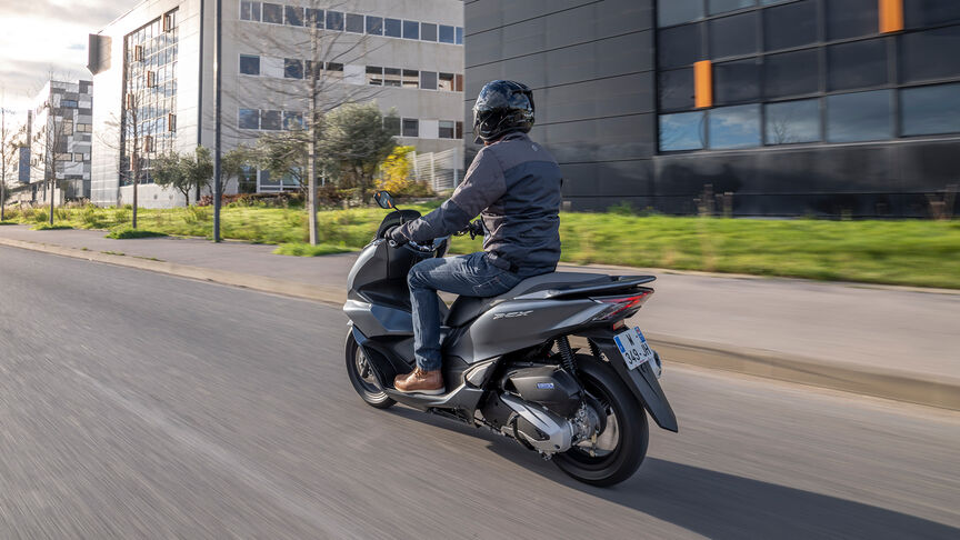 Honda PCX125 - Fotografia dinâmica traseira a ¾ com condutor