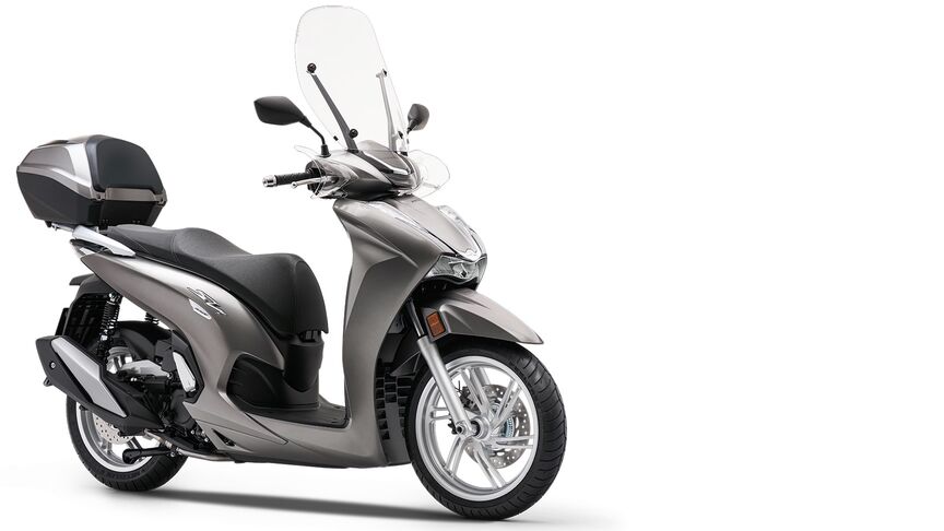 Vista dianteira a três quartos da Honda SH300i com mala traseira e para-brisas.