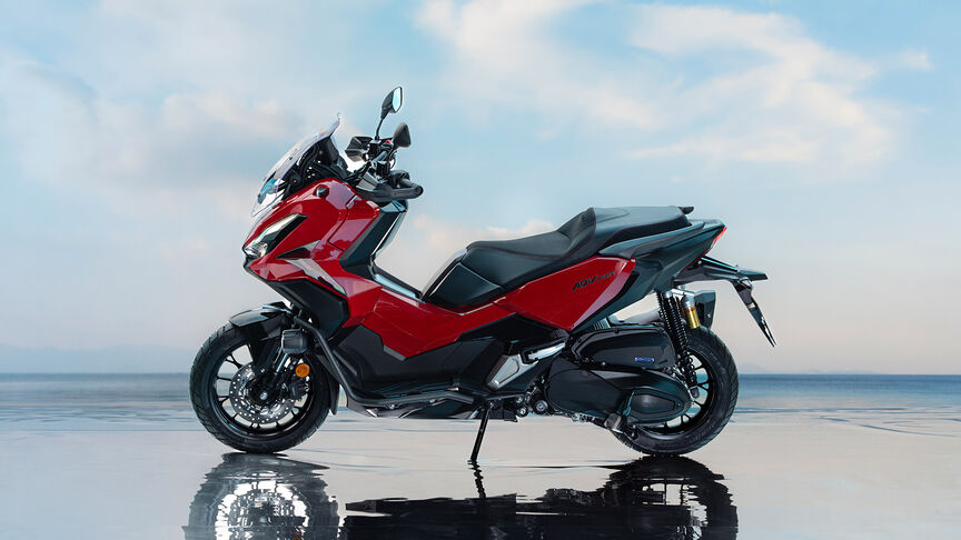 Vista frontal a 3/4 da Honda ADV350 num cenário costeiro.