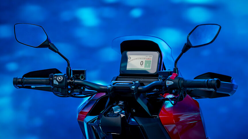Vista frontal a 3/4 da Honda ADV350 num cenário costeiro.