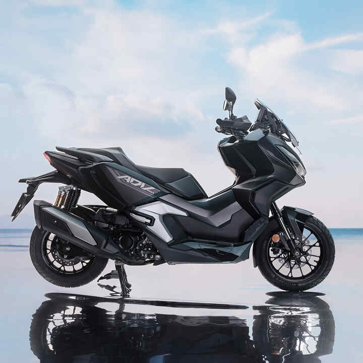 Vista lateral da Honda ADV350 em localização costeira. 