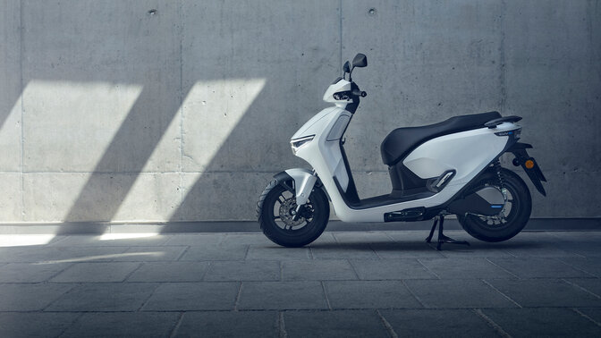 Moto Honda CUV estacionada num cenário de garagem.