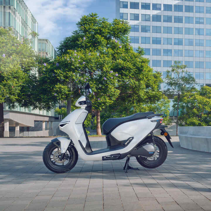 Moto Honda CUV e estacionada num cenário urbano.