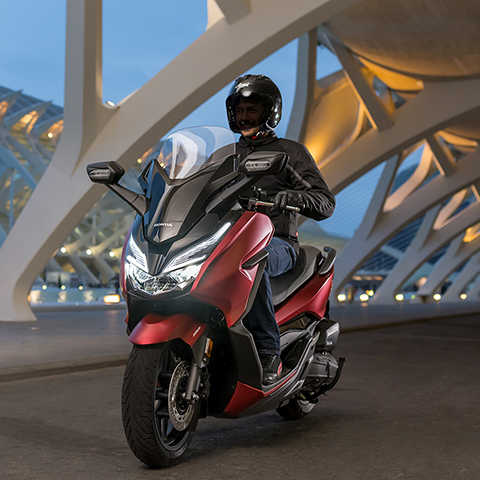 Forza 125, em movimento, vista frontal lateral esquerda a 3 quartos