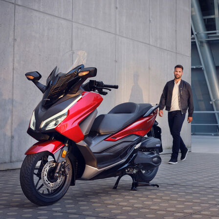 Honda Forza 350 no descanso central com modelo
