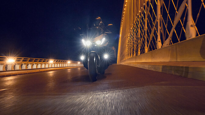 Moto Forza 750 estacionada perto de um cenário junto ao rio.