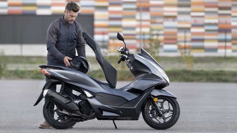 Honda PCX125 - vista a 3 quartos dianteira direita, estacionada, moto cinzenta